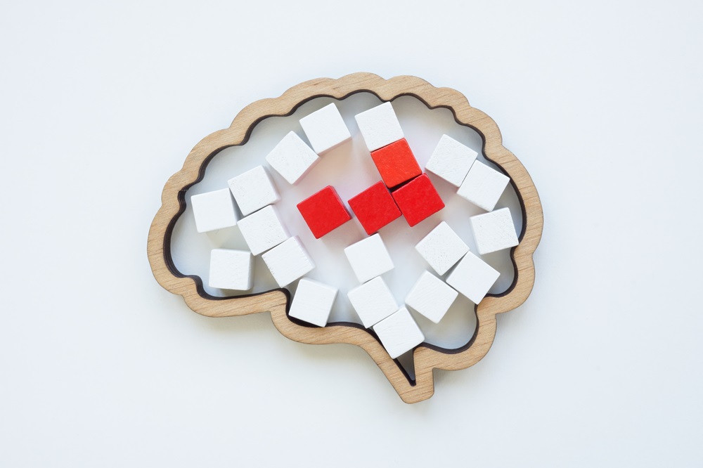 Brain model and red cubes as a concept of disease or pain in the head.